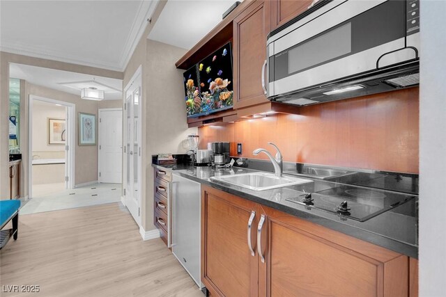 145 E Harmon Ave Unit 2603, Las Vegas, NV 89109 - kitchen with stainless steel microwave, a sink, dark countertops, brown cabinets, and ornamental molding