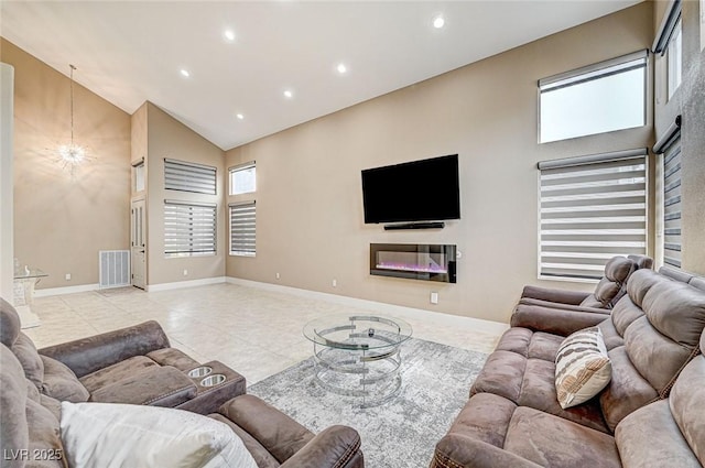 tiled living room with an inviting chandelier and high vaulted ceiling