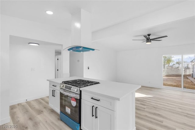 kitchen with white cabinetry, a center island, light hardwood / wood-style flooring, and stainless steel gas range oven