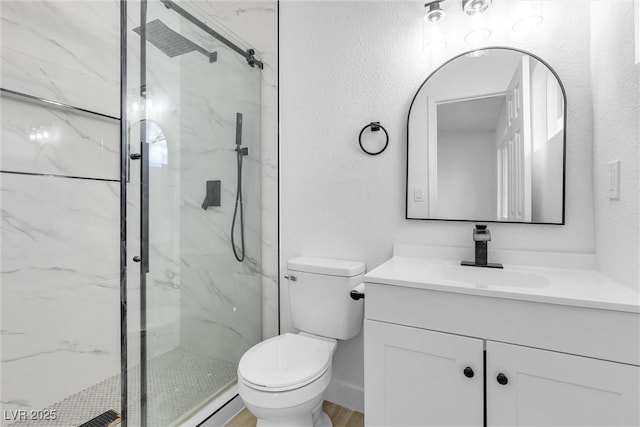 bathroom with vanity, toilet, and a shower with shower door