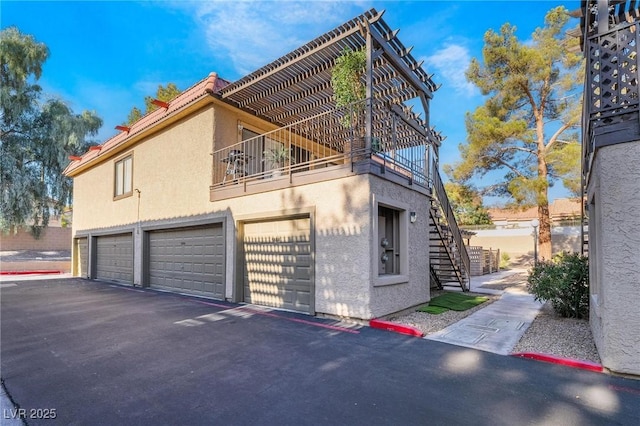 view of side of home featuring a garage and a balcony