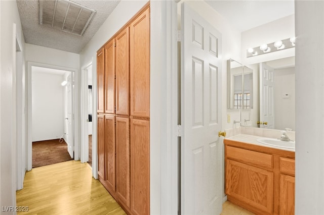 bathroom with vanity, hardwood / wood-style floors, and a textured ceiling