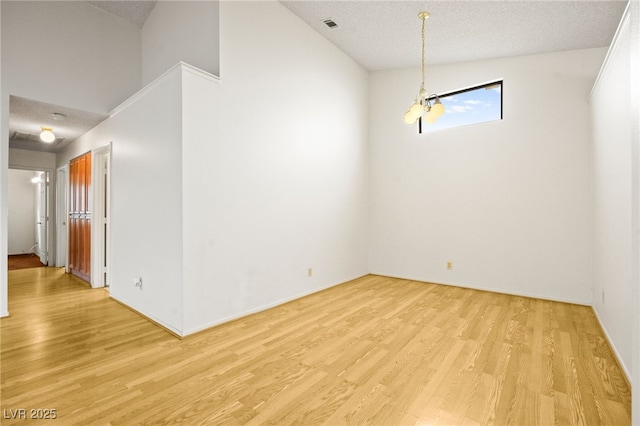 spare room featuring light hardwood / wood-style flooring and a textured ceiling