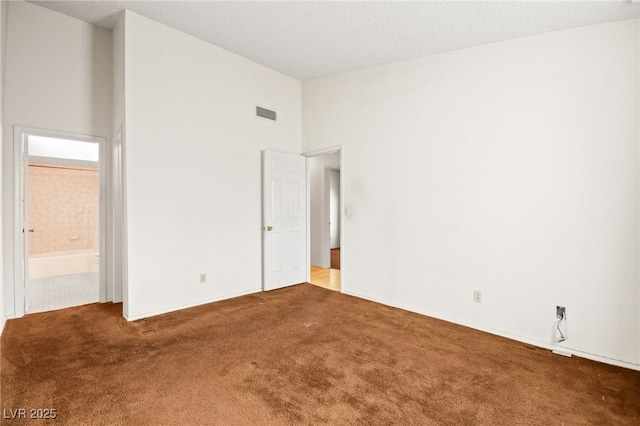 unfurnished bedroom featuring ensuite bathroom, carpet, and high vaulted ceiling