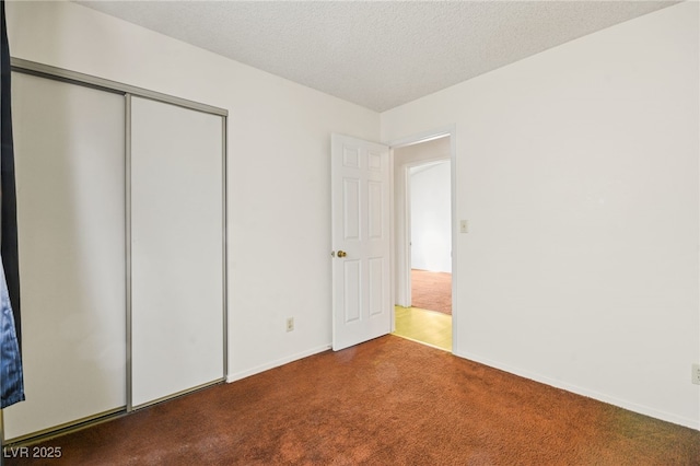 unfurnished bedroom featuring a closet, a textured ceiling, and carpet