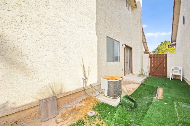 exterior space with central AC unit and a lawn