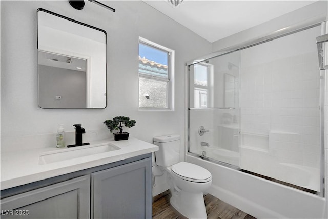 full bathroom with vanity, wood-type flooring, enclosed tub / shower combo, and toilet