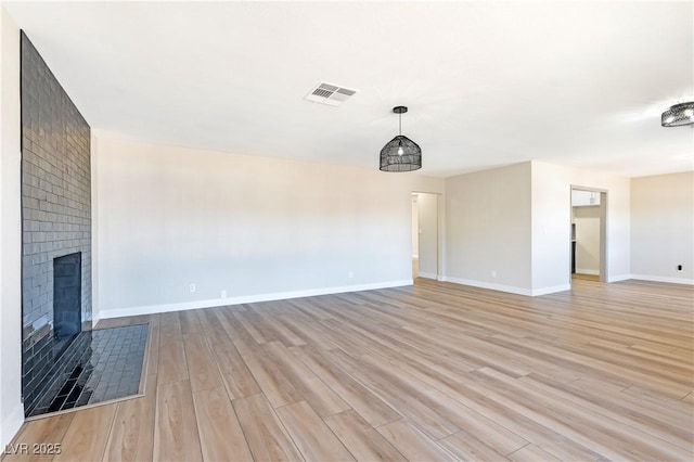 unfurnished living room featuring a fireplace and light hardwood / wood-style flooring