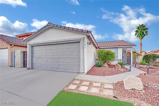 view of front of property with driveway, stucco siding, a garage, and a tiled roof