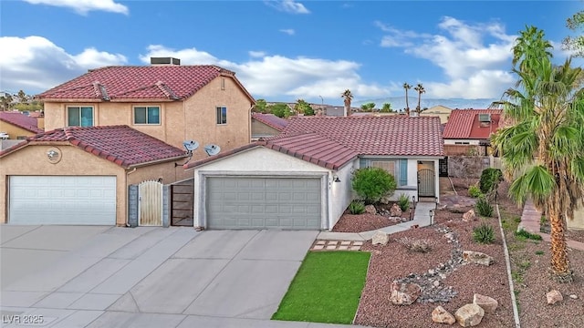 mediterranean / spanish house featuring a tiled roof, concrete driveway, an attached garage, and stucco siding