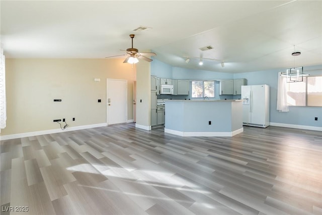 kitchen featuring lofted ceiling, white appliances, baseboards, and visible vents