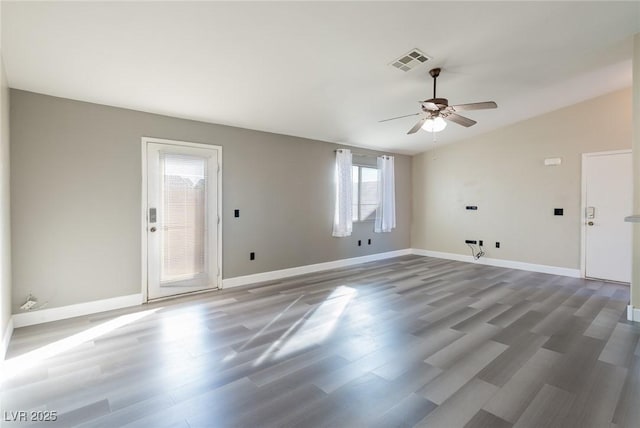 unfurnished room featuring lofted ceiling, visible vents, ceiling fan, wood finished floors, and baseboards