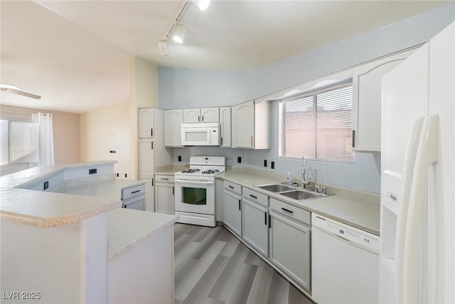 kitchen featuring lofted ceiling, white appliances, a sink, and a wealth of natural light