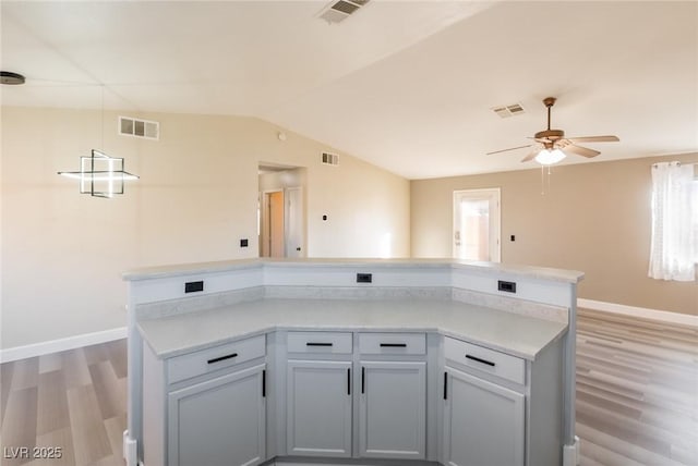 kitchen with light wood-style floors, lofted ceiling, and visible vents