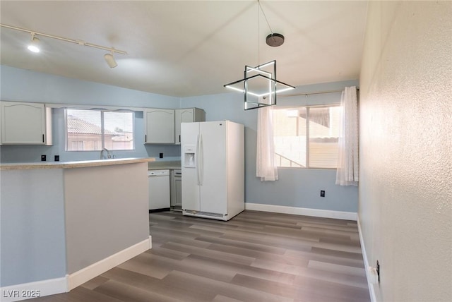 kitchen with light countertops, white appliances, wood finished floors, and baseboards