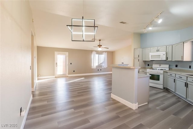 kitchen with white appliances, visible vents, light wood-style floors, vaulted ceiling, and light countertops