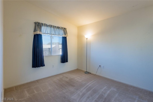 unfurnished room featuring lofted ceiling and carpet flooring