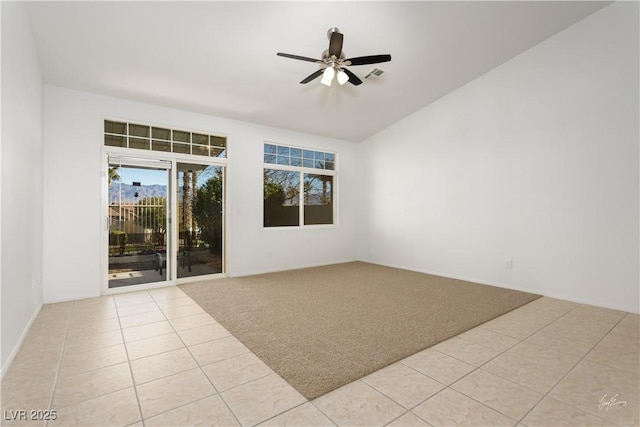 spare room featuring vaulted ceiling, ceiling fan, and light colored carpet