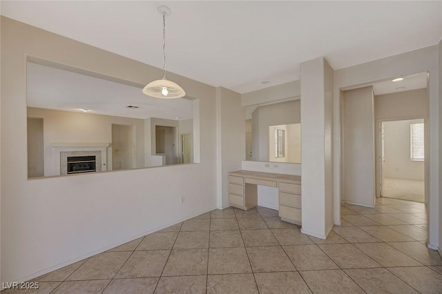 unfurnished room with light tile patterned flooring and a tiled fireplace