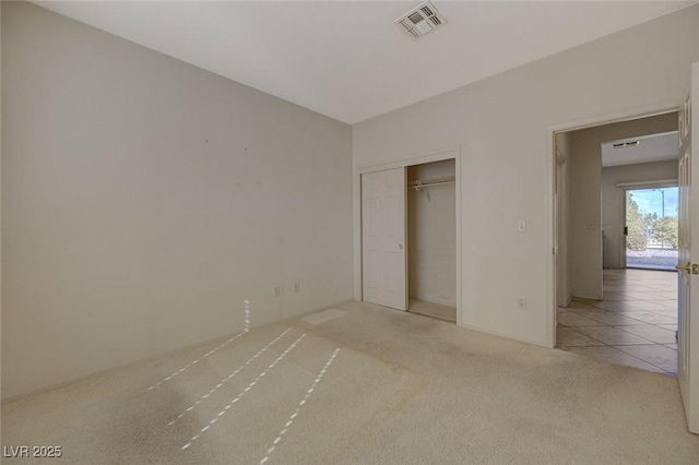 unfurnished bedroom with light carpet and a closet