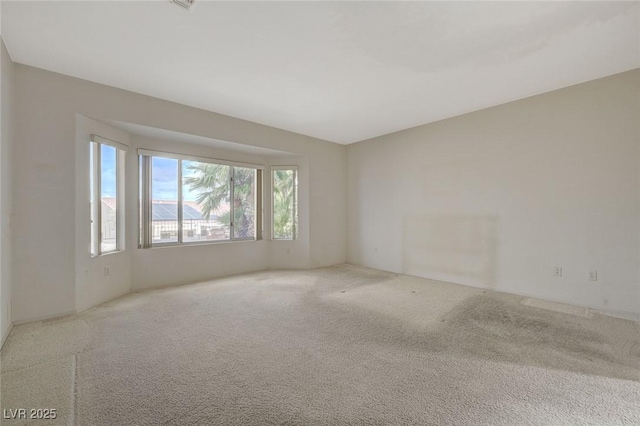 unfurnished room featuring light carpet