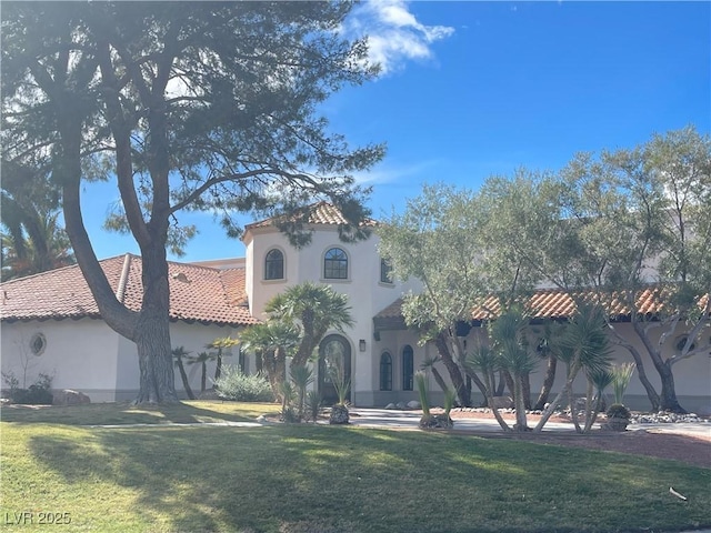 mediterranean / spanish-style home with a front yard