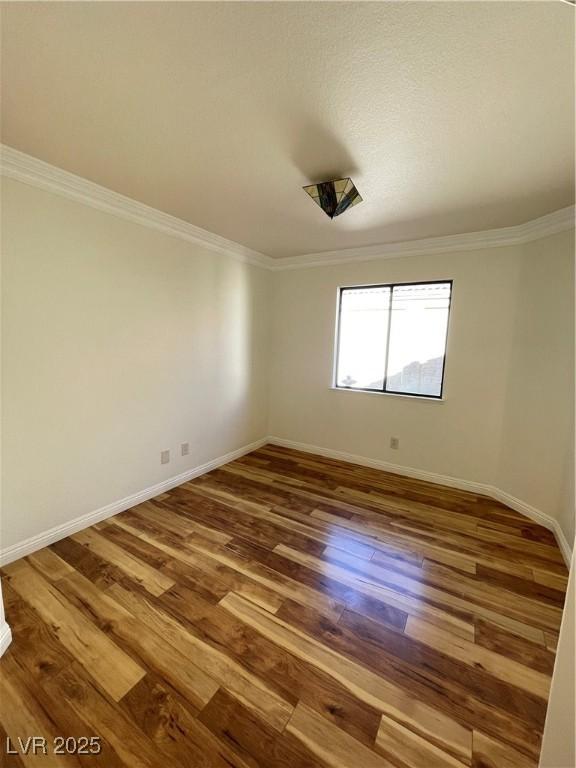 unfurnished room with wood-type flooring and ornamental molding