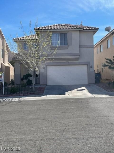 view of front of house with a garage, fence, driveway, a tiled roof, and stucco siding