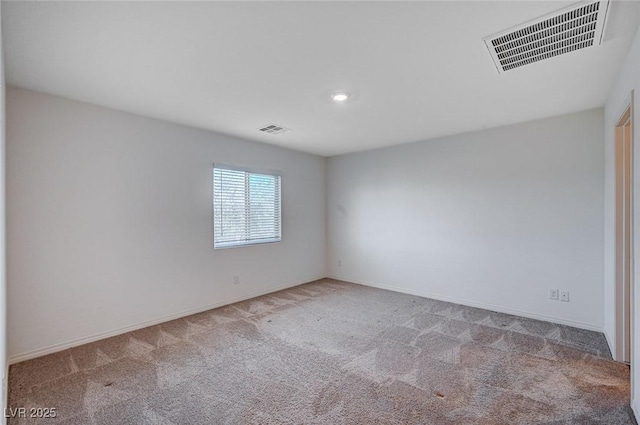 unfurnished room featuring baseboards, visible vents, and light colored carpet