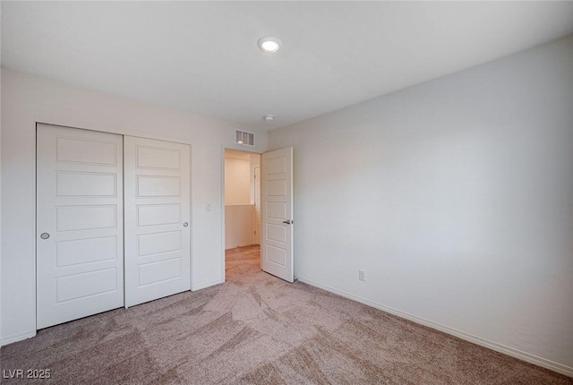 unfurnished bedroom with baseboards, visible vents, light colored carpet, a closet, and recessed lighting