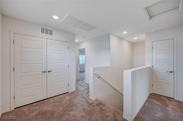 corridor with carpet, recessed lighting, visible vents, attic access, and an upstairs landing