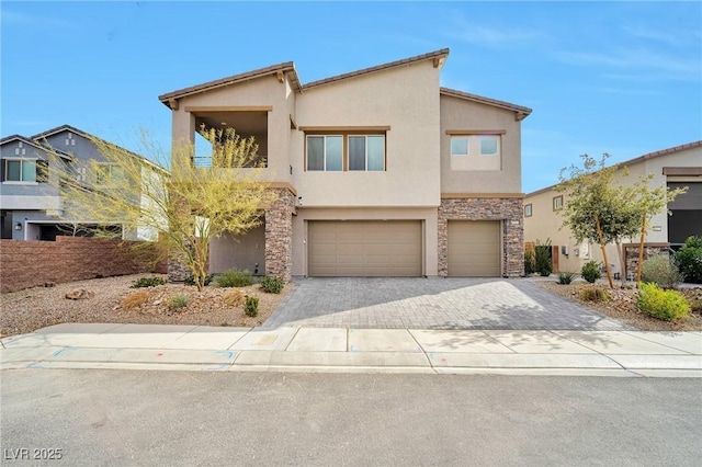 contemporary home featuring stone siding, decorative driveway, an attached garage, and stucco siding