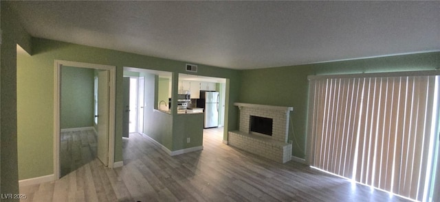 unfurnished living room with a fireplace and hardwood / wood-style floors