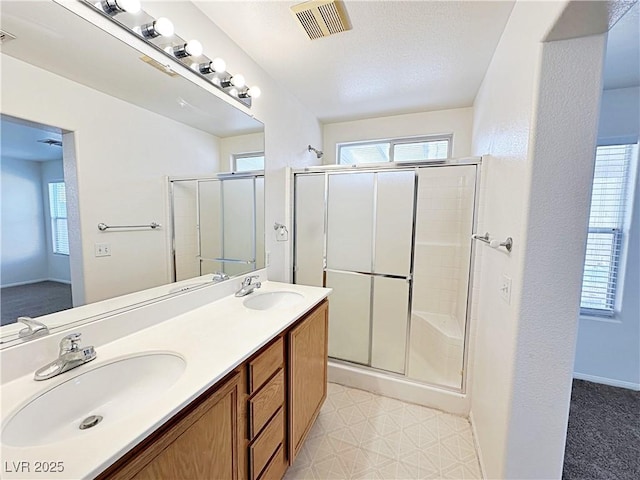 11036 Parete Ct, Las Vegas, NV 89141 - bathroom featuring a shower stall, double vanity, healthy amount of natural light, and tile patterned floors