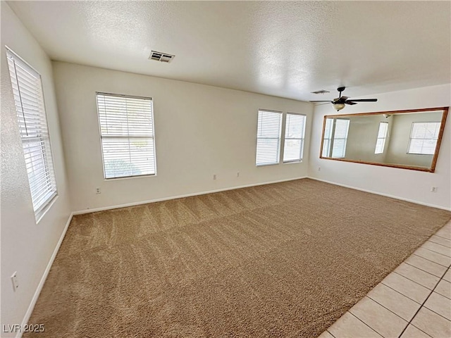 11036 Parete Ct, Las Vegas, NV 89141 - spare room featuring a textured ceiling, light colored carpet, a ceiling fan, and light tile patterned floors