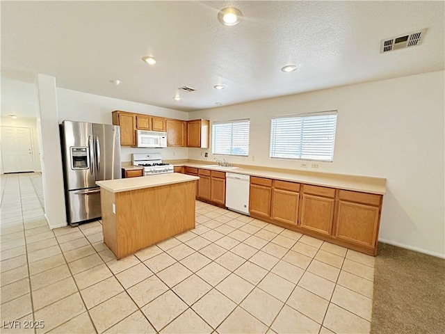 11036 Parete Ct, Las Vegas, NV 89141 - kitchen featuring white appliances, light countertops, a center island, light tile patterned floors, and recessed lighting