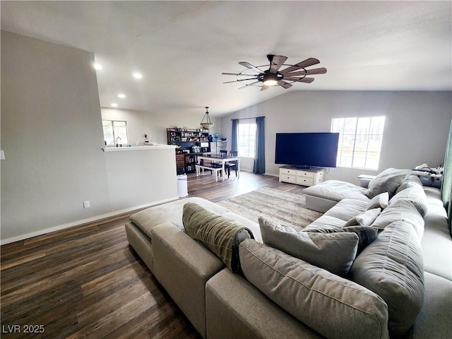 living room with wood-type flooring, vaulted ceiling, a wealth of natural light, and ceiling fan