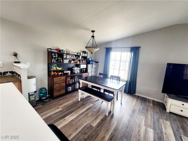 dining space with dark hardwood / wood-style flooring and vaulted ceiling