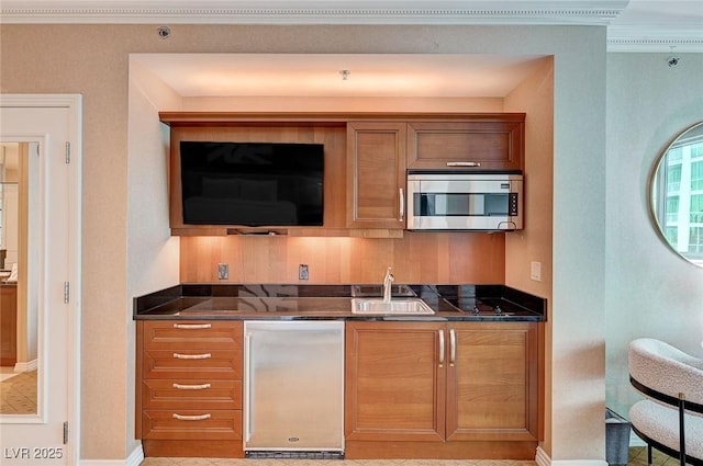 kitchen featuring refrigerator, sink, and ornamental molding