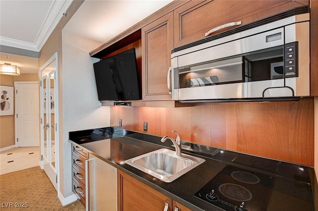 kitchen featuring sink, black electric cooktop, and ornamental molding