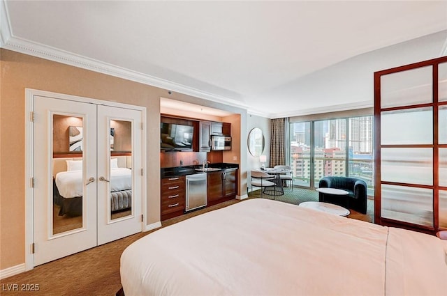 bedroom with french doors, crown molding, carpet floors, and sink