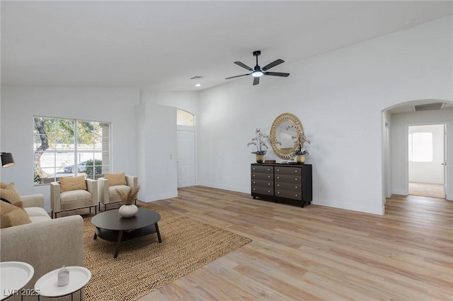 living room with vaulted ceiling, ceiling fan, and light wood-type flooring