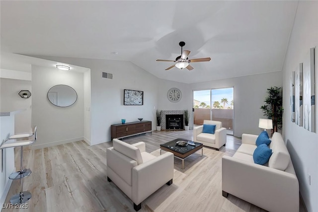 living room featuring vaulted ceiling, ceiling fan, and light wood-type flooring