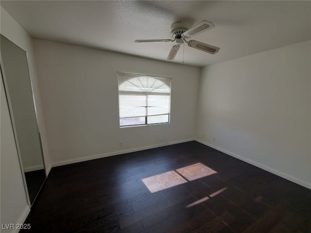 unfurnished room with dark wood-type flooring and ceiling fan