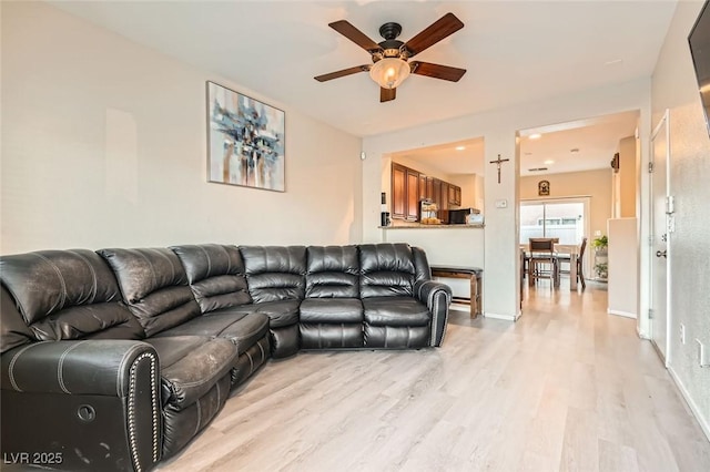 living room featuring ceiling fan and light hardwood / wood-style flooring