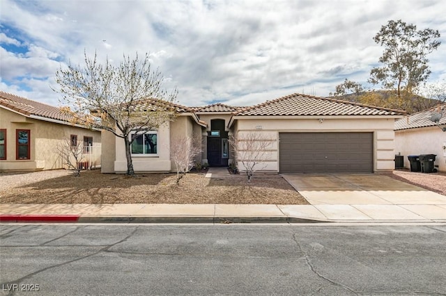 view of front of house with stucco siding, a garage, concrete driveway, and a tile roof