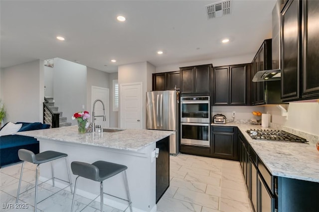 3192 Bormida Ave, Henderson, NV 89044 - kitchen featuring stainless steel appliances, a sink, light marble finish floors, a kitchen bar, and recessed lighting