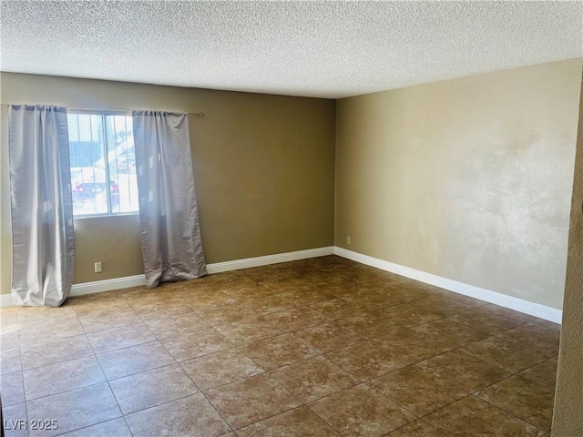 spare room with baseboards and a textured ceiling