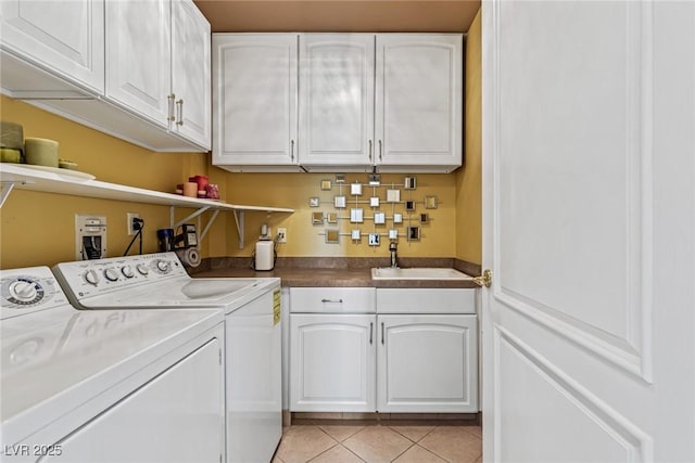 laundry area featuring light tile patterned floors, independent washer and dryer, cabinet space, and a sink