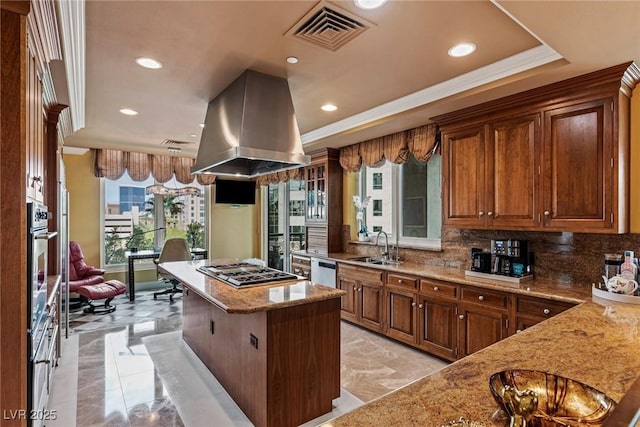 kitchen featuring visible vents, a kitchen island, appliances with stainless steel finishes, island range hood, and a sink